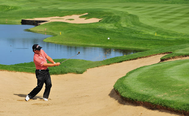 24sport: Graeme McDowell plays his bunker shot on the 18th