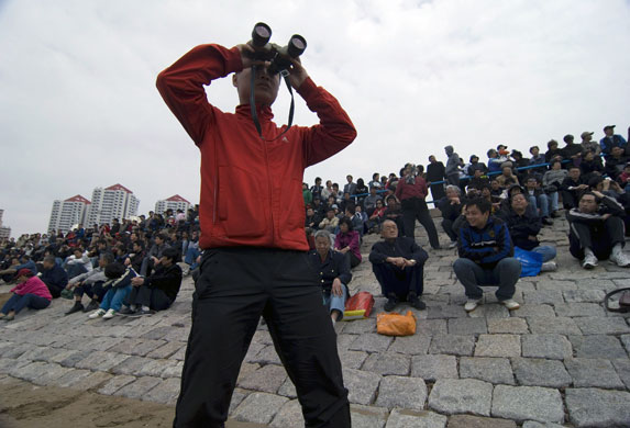Chinese fleet review: Local citizens gather and wait to watch the Chinese PLA navy fleet parade.