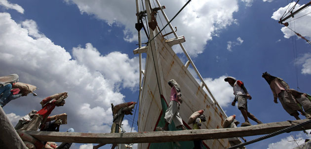 24 hours in pictures: Labourers carry sacks of cement at a Jakarta harbour