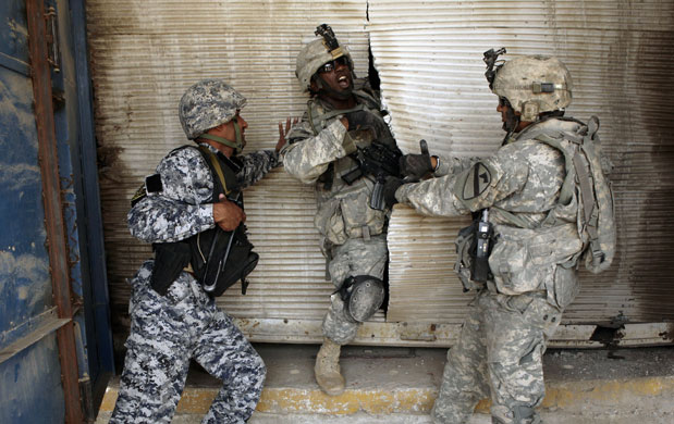 24 hours in pictures: U.S. Army soldier squeezes through a metal door