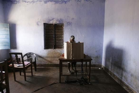 24 hours in pictures: An Indian an casts his vote