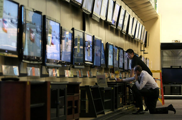 Week in business: Customers look at flat screen televisions at a Best Buy in San Francisco.
