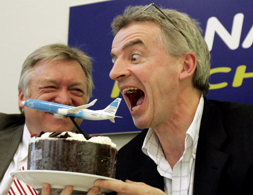 Week in business: CEO of Ryanair Michael O'Leary gestures as he pretends to bite a toy plane.