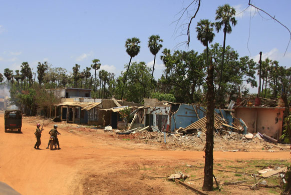 Sri Lanka : Sri Lankan government soldiers walk past destoyed buildings in Putumatalan 