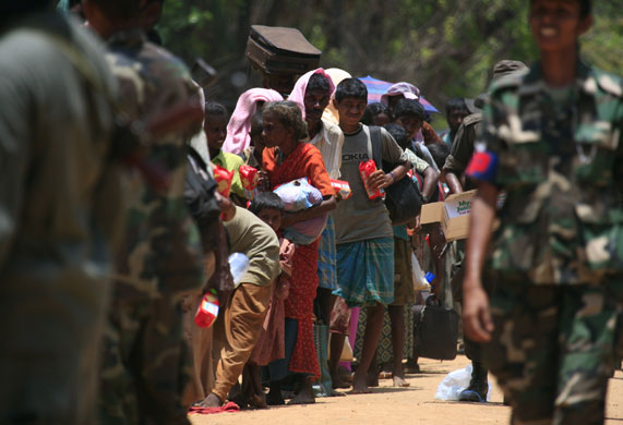 Sri Lanka : Tamil civilians hold food given by Sri Lankan government soldiers 