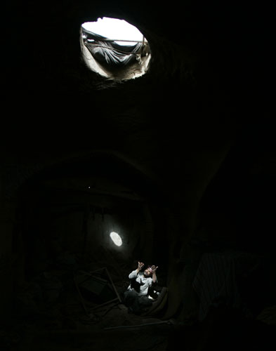 24 hours in pictures: emetery worker Mohammed Ameen prays inside a grave in Najaf