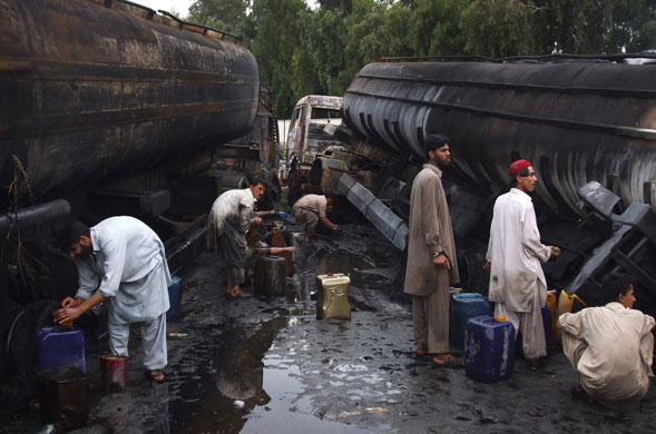 24 hours in pictures: Pakistani workers collect oil spilled from oil-tankers