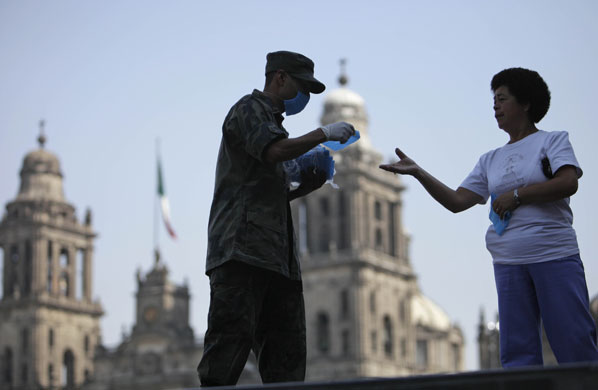 Swine flu: soldier hands out surgical masks during swine flu outrbreak in mexico city