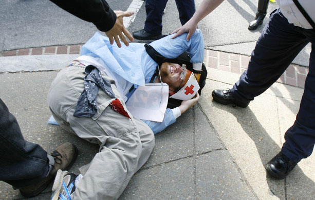 24 hours in pictures: A demonstrator lies injured during a protest outside the IMF in Washington