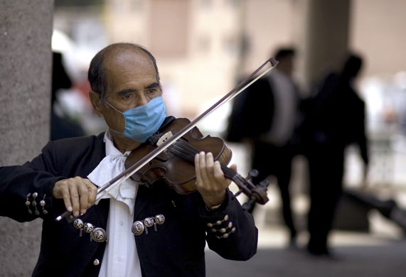 Swine flu : A Mariachi wears a mask as he plays the violin in Mexico City