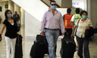 People wear masks as they walk with their bags inside Mexico City's international airport