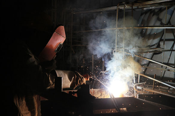 27 April 2009: Shanghai, China: A worker welds parts of a foundation