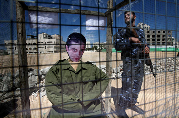 27 April 2009: Gaza City: Policemen stand near an effigy of Israeli soldier Gilad Schalit