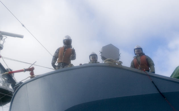 Crew members aboard the Yushin Maru No 3 gesture towards Sea Shepherd activists 