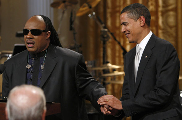 obama 100 days : U.S. President Barack Obama stands next to musician Stevie Wonder