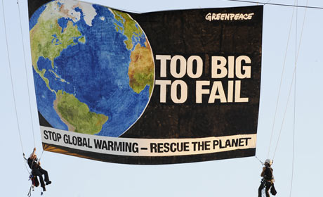 Greenpeace activists display a banner from a crane near the State Department in Washington 