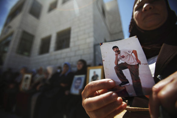 28 April 2009: Ramallah, West Bank: A woman holds a portrait of her son during a protest