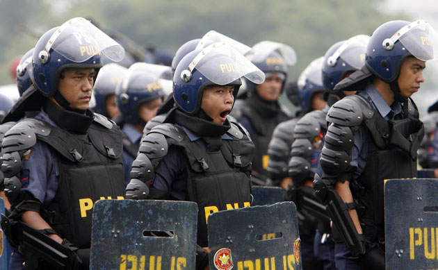 28 April 2009: Manila, Philippines: A riot policeman yawns during a drill