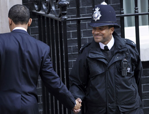 obama 100 days : Barack Obama shakes hands with a police officer outside 10 Downing Street 