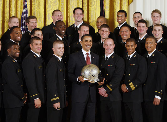 100 days obama: US President Barack Obama poses with the Naval Academy football team.