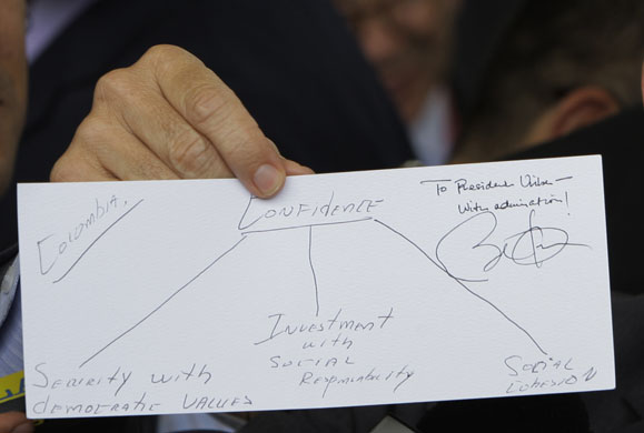 100 days obama: Alvaro Uribe displays a diagram he drew for President Barack Obama
