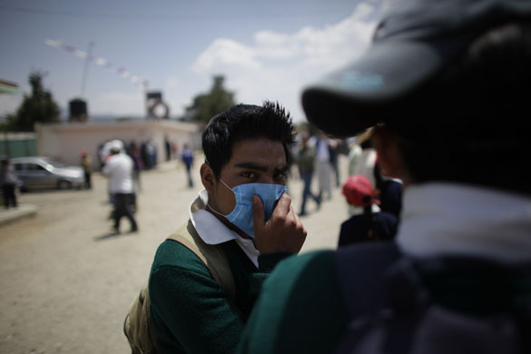 Swine flu La Gloria: A youth wearing a face mask stands in La Gloria
