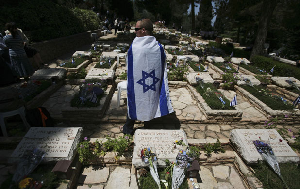 29 April 2009: Jerusalem, Israel: A man stands near the grave of a relative