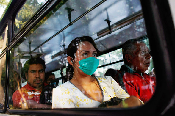 29 April 2009: Mexico City, Mexico: A woman wears a surgical mask as she rides on a bus
