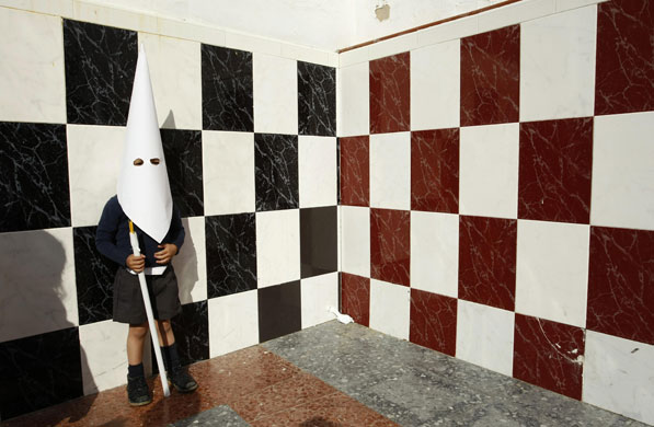 24 hours in pictures: A boy wearing a hood in Seville