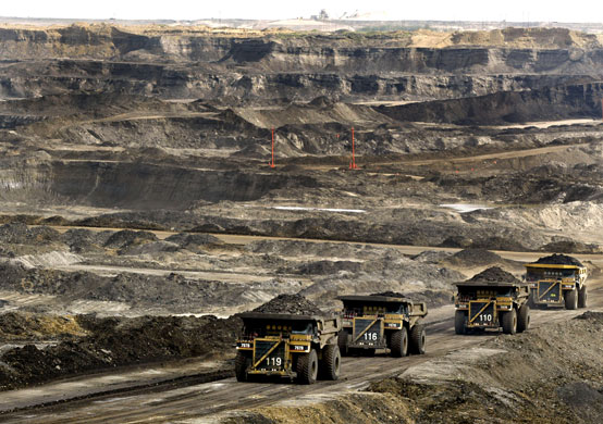 Week in Business: Mining trucks carry loads of oil laden sand at Albian Sands.