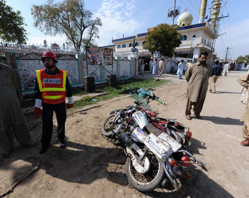Pakistan suicide attack: Bystanders gather at the site of a suicide bomb outside a mosque in Chakwal