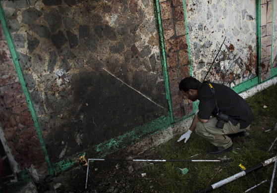 Pakistan suicide attack: A police officer collects evidence following the explosion