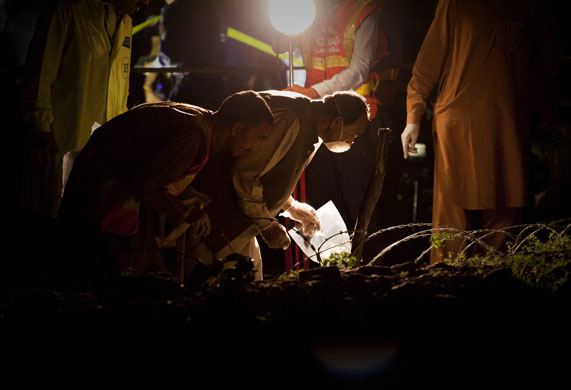 5 April 2009: Islamabad: Police officers collect evidence at the site of an explosion