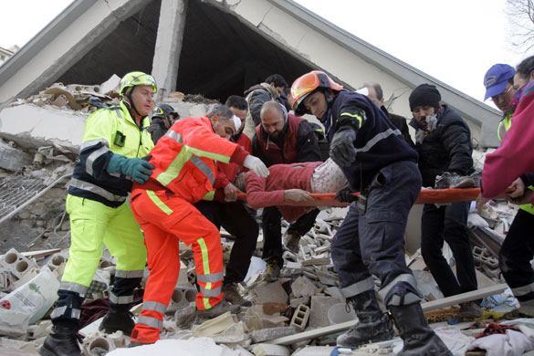 Italy earthquake: Firefighters carry a woman out of a crumbled home