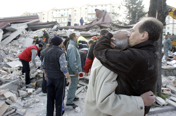 Earthquake in Italy: People stand amidst debris