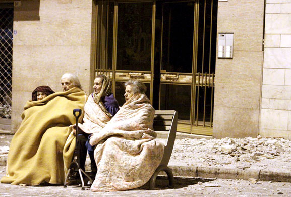 Earthquake in Italy: Elderly women sit in a street next to rubble