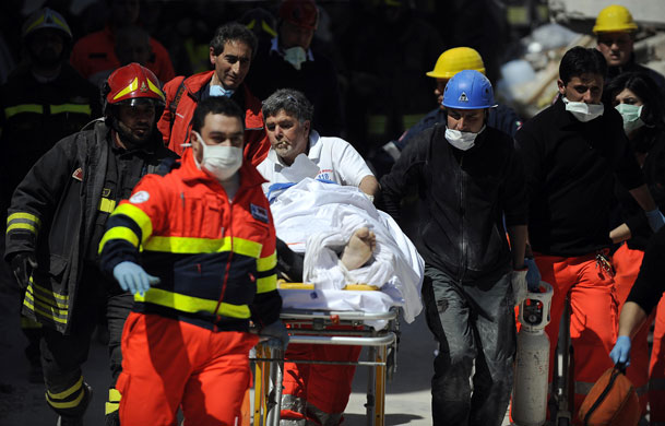 earthquake in Italy: Rescuers with an injured man who was recovered from a collapsed building