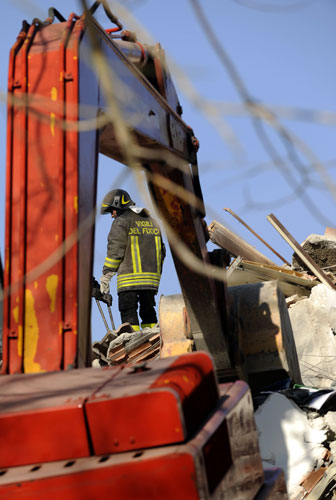 earthquake in Italy: Fire brigade employees work on a collapsed building
