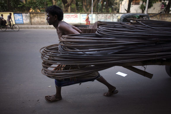 6 April 2009: Dhaka, Bangladesh: A labourer pulls a cart full of rods