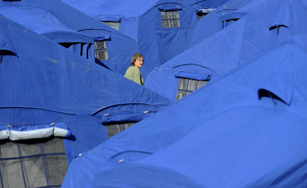 L'Aquila earthquake: A woman walks through a refugee camp setup just outside L'Aquila