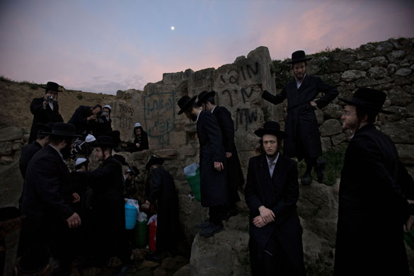 24 hours in pictures: Ultra-Orthodox Jewish men stand next to a well