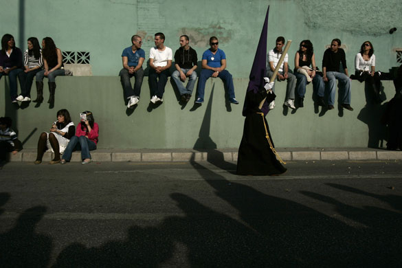 24 hours in pictures: Penitent takes part in a procession in Malaga