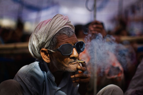 24 Hours in pictures: A supporter of Mayawati Kumari smokes