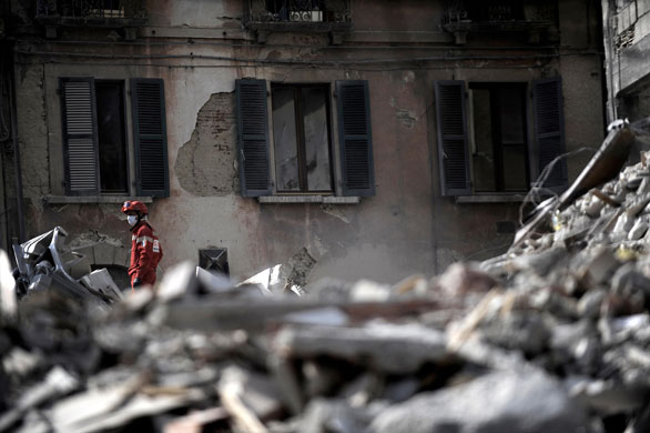 Earthquake aftershock: A rescue worker stands on rubble in the centre of L'Aquila