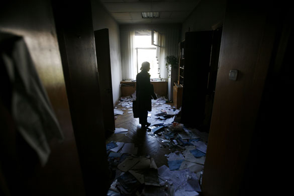8 April 2009: Moldova: A woman surveys the damage the burned parliament building