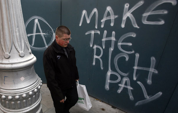Week in Business: A man walks past graffiti on a wall in Dublin