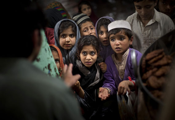 24 hours in pictures: Pakistani children ask for food during food distribution