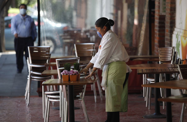 Mexico swine flu: A waiter wears a face mask near the La Buena Tierra restaurant.