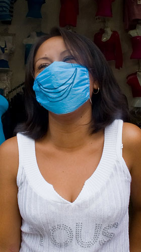 Swine flu face masks: A shop assistant wears a surgical mask to avoid swine flu in Mexico City