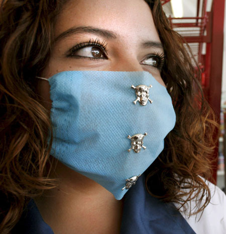Swine flu face masks: A woman wears a protective mask decorated with skulls, in Leon, Mexico